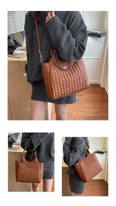 Detail of retro dark brown quilted tote bag with metal chain handles and shoulder strap