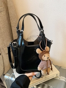 Chic black glossy bucket bag with cute bear charm and adjustable strap for women