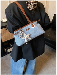 Détail du sac à épaule en jean bleu avec pendentif étoile et chien ballon argenté