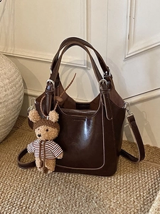Minimalist dark brown bucket bag with stitching details and cute bear charm pendant