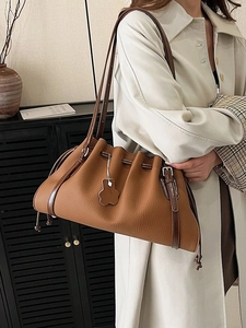 Brown vintage pleated tote bag with lychee leather texture worn with a beige trench coat