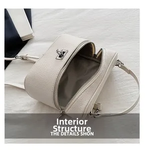 Detailed interior of a white litchi leather bag with herringbone lining and silver metal locks