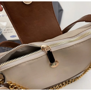 Detail view of the quilted patchwork bag featuring gold zipper and metal chain strap
