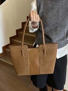 Caramel brown vintage patchwork tote bag with contrast stitching on wooden stairs