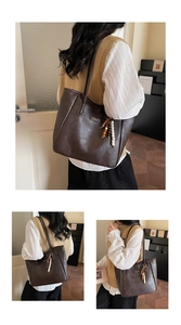 Detail of soft dark brown leather tote bag with stylish beaded tassel and fashion logo