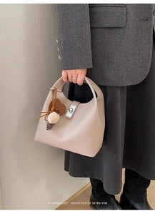 Detail of lychee pattern leather bucket bag with silver lock and heart charm