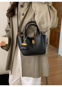 Minimalist black faux leather bag with gold twist lock and a mini pouch pendant