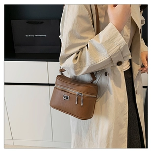 Detail of brown litchi pattern leather box bag with silver metal swivel lock and strap