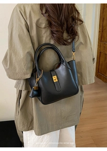 Detailed view of a black retro leather tote with gold hardware and chain accessory