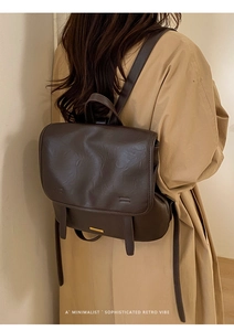 Close-up of vintage dark brown PU leather backpack with a gold metal accent on the flap