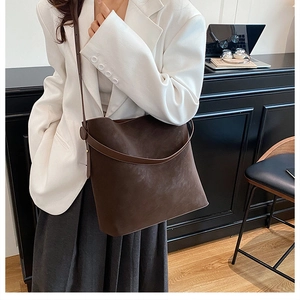 Deep brown matte suede tote bag shown in a professional office setting for daily commute