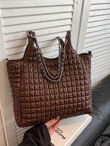 Minimalist brown quilted tote bag with chain strap and silver triangle logo in soft light