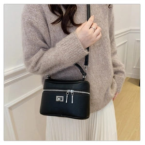 Close-up of black litchi pattern box bag with silver hardware on a model outfit