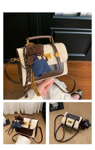Detail of vintage beige suede crossbody bag with brown leather trim and bear charm
