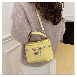 Casual yellow box handbag with lychee texture and adjustable strap worn by a model