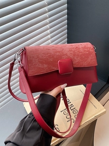 Rote Schultertasche mit Textur-Einsatz und Silberschnalle in urbaner Lifestyle-Umgebung