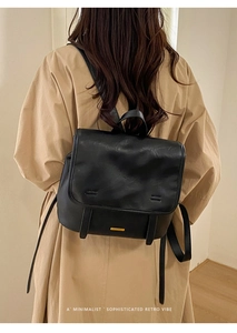 Zaino minimalista in pelle PU nera con logo dorato e stile retrò indossato da un modello
