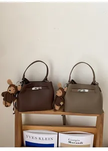 Litchi texture leather bucket bags in brown and taupe with silver buckle and bear charm