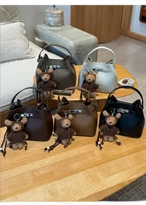 Detailed view of five colorful bucket bags in lychee leather with cute bear charms