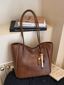 Retro dark brown leather tote bag with a wooden bead charm for daily commuting