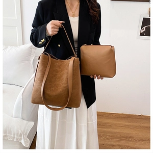 Brown frosted leather tote bag with inner pouch shown on a model in a modern office