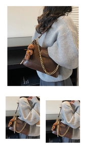 Close-up of brown quilted shoulder bag with gold chain strap and cute bear charm
