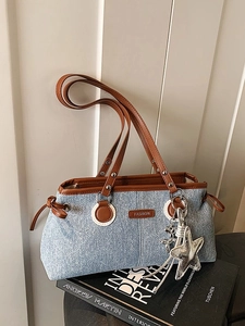 Sac à épaule en denim bleu clair avec garniture en cuir brun et pendentif étoile