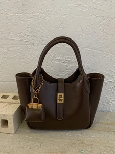 Minimalist dark brown structured handbag with twin handles and golden twist lock