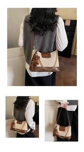 Detail of color-block crossbody bag with gold chain strap and plush bear charm