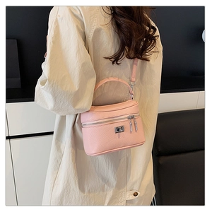 Pink lychee grain box handbag shown on a model in a trench coat, crossbody style