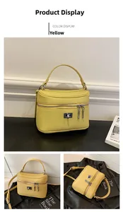 Detail of yellow lychee grain leather handbag with square metal twist lock and dual zippers