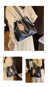 Detail der minimalistischen schwarzen PU-Leder-Einkaufstasche mit braunem Plüsch-Hundeanhänger