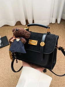 Vintage black leather crossbody bag with teddy bear pendant and gold hardware details