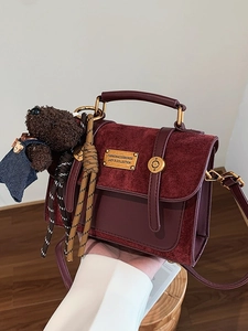 Burgundy vintage handbag in textured leather and suede with a cute bear plush keychain