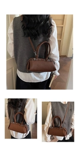 Detail of vintage brown baguette bag with white stitching and silver hardware
