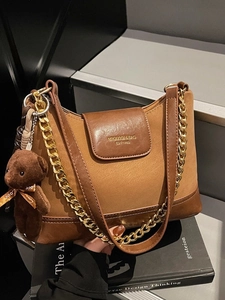 Brown patchwork quilted shoulder bag with gold chain strap and teddy bear charm