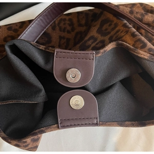 Vue détaillée du fermoir magnétique en métal sur le sac à bandoulière léopard