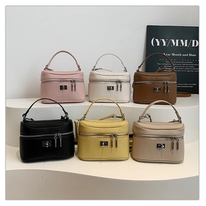 Litchi pattern box bags in six colors with metal turn-lock and top handles on white stairs