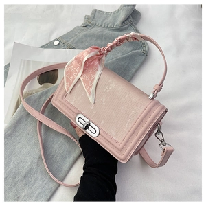 Detail der rosa geprägten PU-Handtasche mit Metalldrehverschluss und Seidenschal-Griff