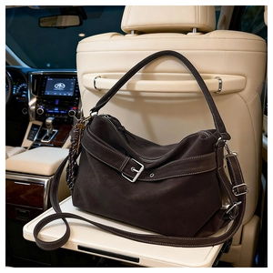 Detail view of coffee brown suede tote bag with contrast stitching on luxury car interior
