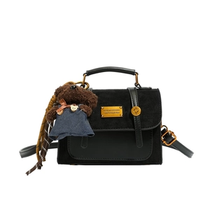 Retro black leather backpack with gold hardware and a cute brown plush bear charm