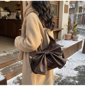 Deep brown large tote bag with retro lace trim and oversized bow detail on a model