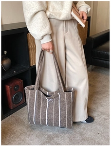 Detailed texture of brown striped canvas tote bag with a decorative bow on the opening