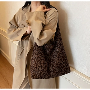 Grand sac fourre-tout à imprimé léopard porté avec un trench pour un look décontracté