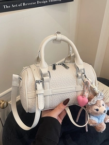 Chic beige Boston handbag in embossed faux leather with crossbody strap and charms