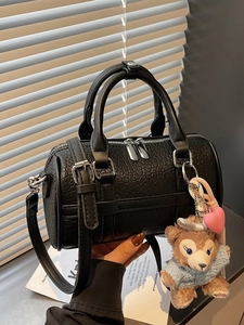 Classic black embossed leather Boston bag with plush charm and adjustable shoulder strap