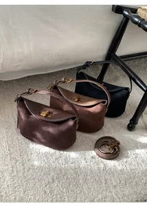 Trois sacs hobo en daim marron foncé, marron et noir avec fermoirs rotatifs dorés