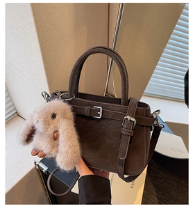 Détails du sac à main en daim marron foncé avec boucles métalliques et charme lapin en peluche