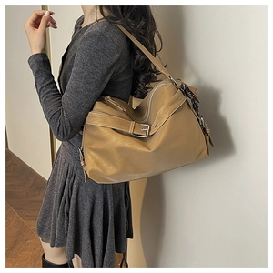 Detail view of large dark camel tote bag with metallic buckles and soft leather texture