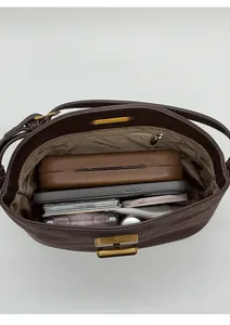 Vue de dessus de l'intérieur spacieux du sac en daim marron avec poche zippée et objets